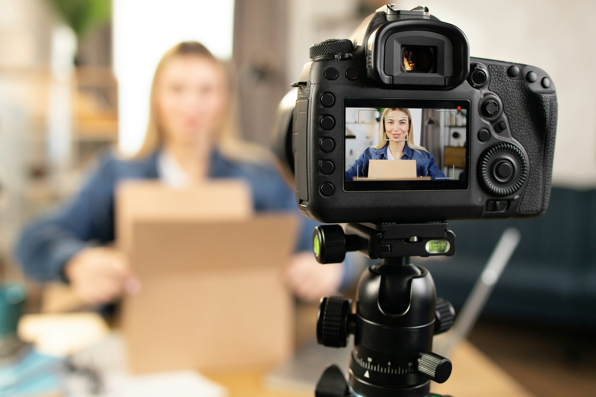 Young woman unboxing parcel and recording video stream